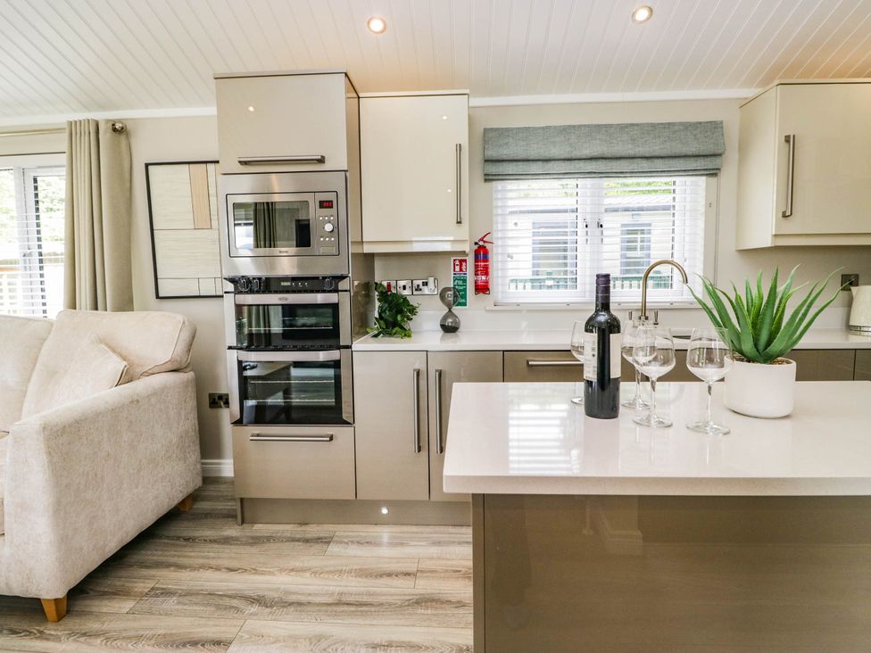 A kitchen with a countertop, oven, and seating area at 19 Pony Meadow near White Cross Bay