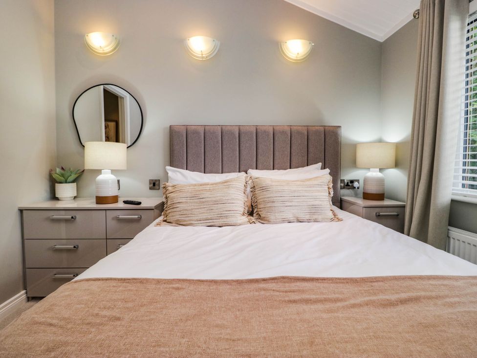 A bedroom with a bed and bedside tables at 19 Pony Meadow near Troutbeck Bridge