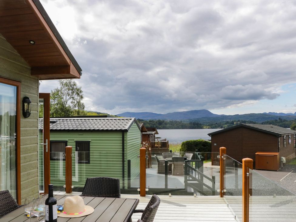 A view of a lake and cabins from a deck at 19 Pony Meadow White Cross Bay near Troutbeck Bridge
