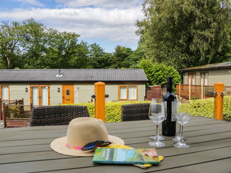 An outdoor table with glasses and a bottle at 19 Pony Meadow White Cross Bay near Troutbeck Bridge