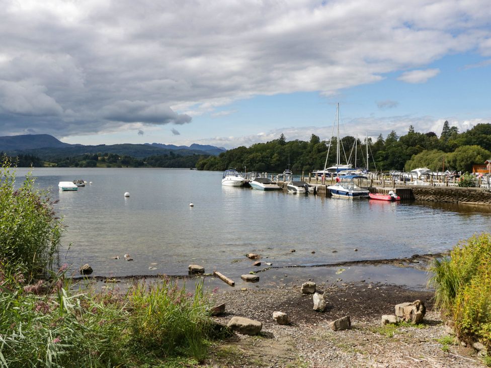 A lakeside view with boats moored at the pier at 19 Pony Meadow White Cross Bay near Troutbeck Bridge