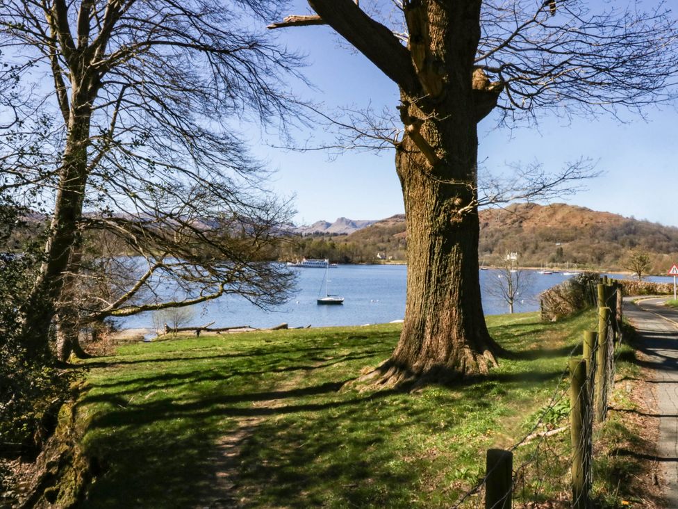 A view of a lake with boats and trees at 19 Pony Meadow White Cross Bay near Troutbeck Bridge