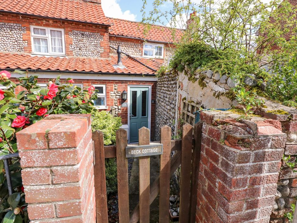 A garden entrance with a wooden gate at Beck Cottage in Sheringham