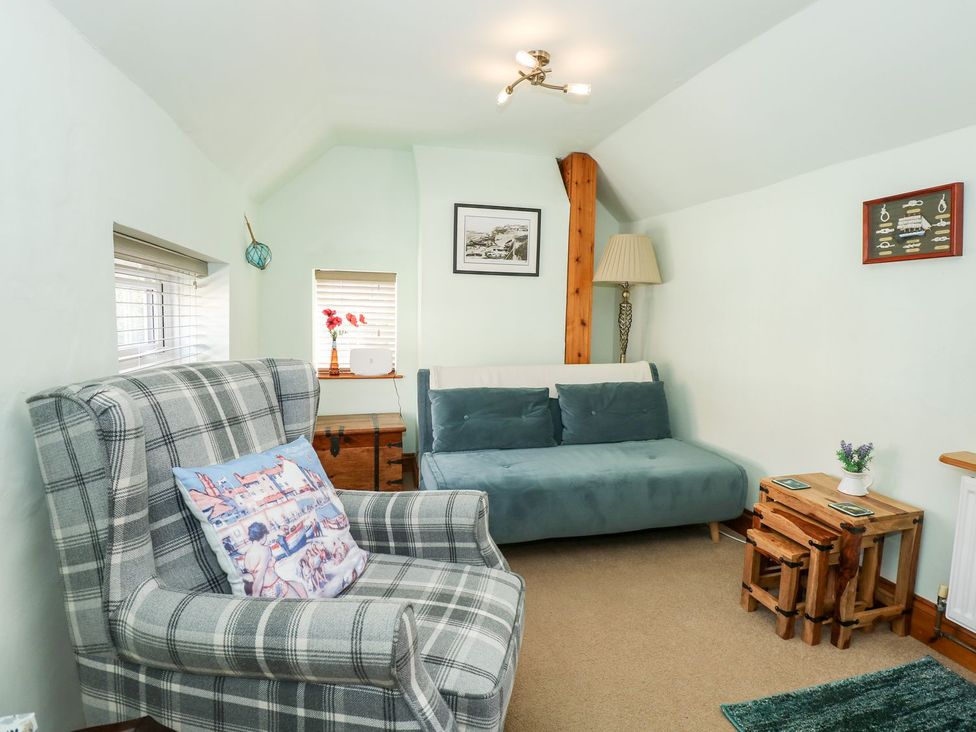 A living room with a chair and a sofa at Beck Cottage in Sheringham