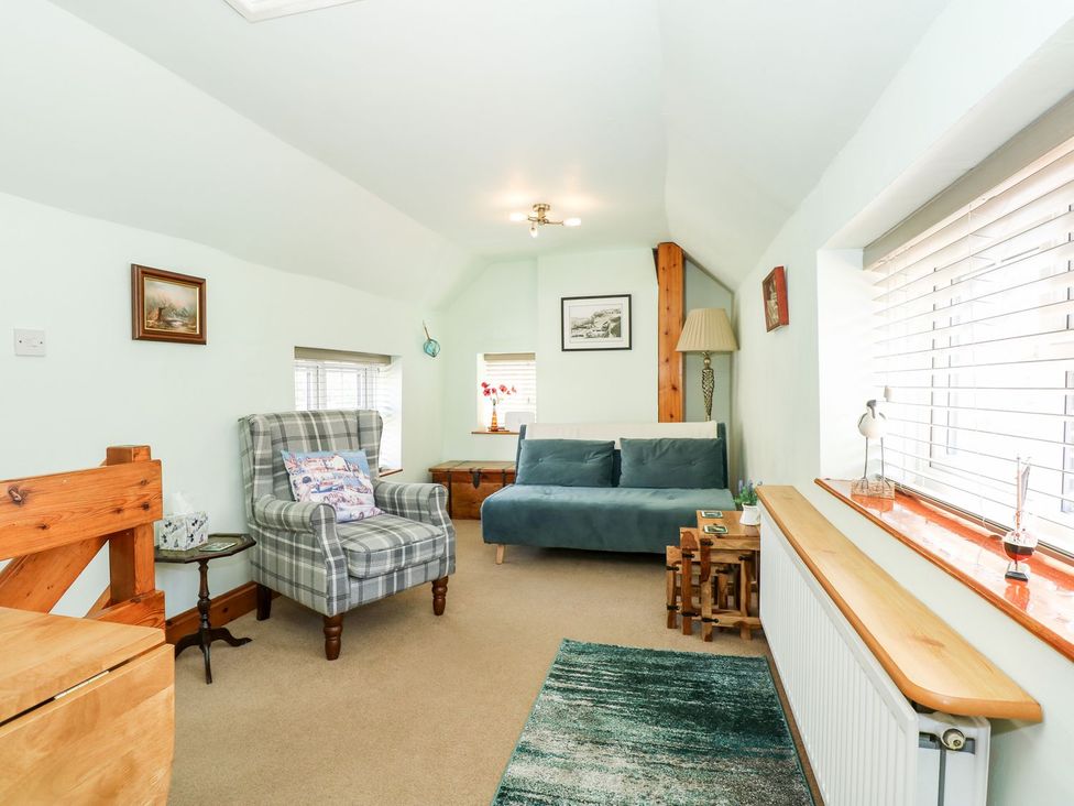 A snug room with a sofa and armchair at Beck Cottage in Sheringham