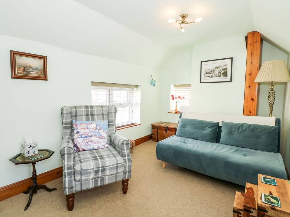 A living room with a sofa and chair at Beck Cottage in Sheringham