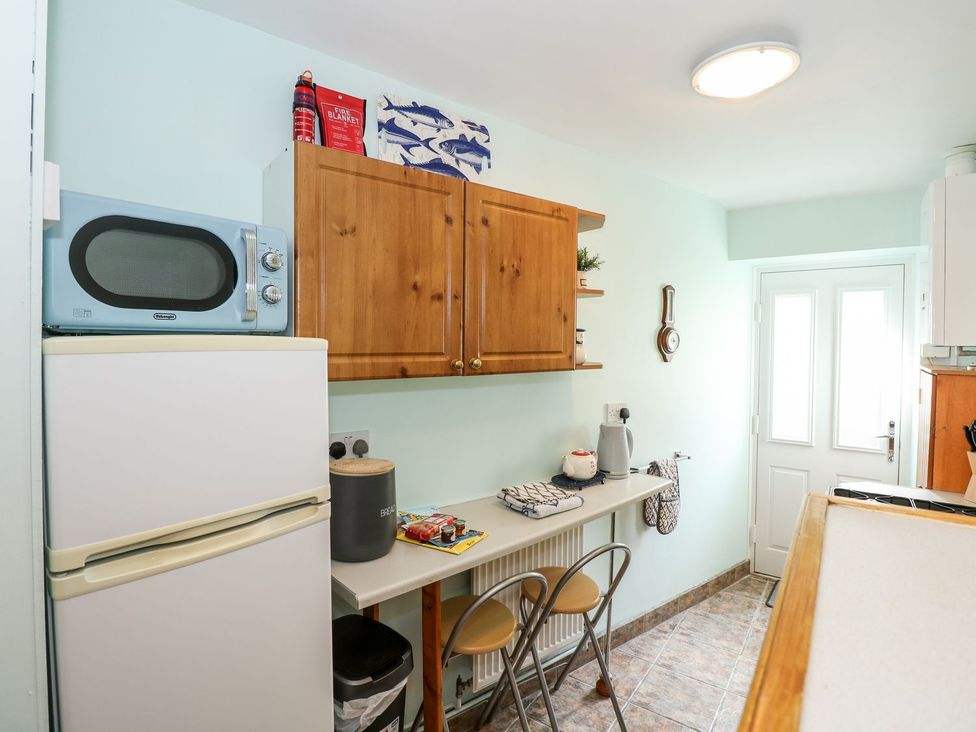 A kitchen with a refrigerator and microwave at Beck Cottage in Sheringham