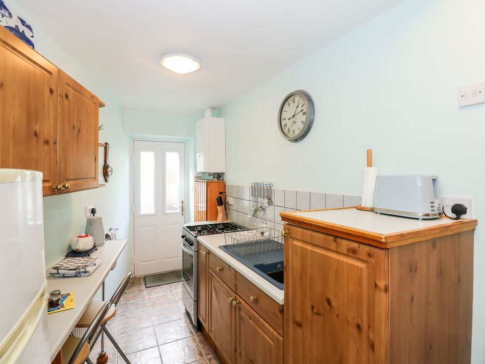 A kitchen with cabinets and appliances at Beck Cottage in Sheringham