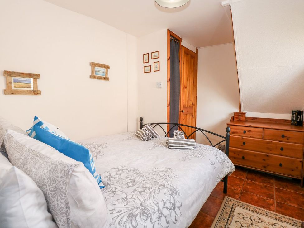 A bedroom with a bed and a dresser at Beck Cottage in Sheringham