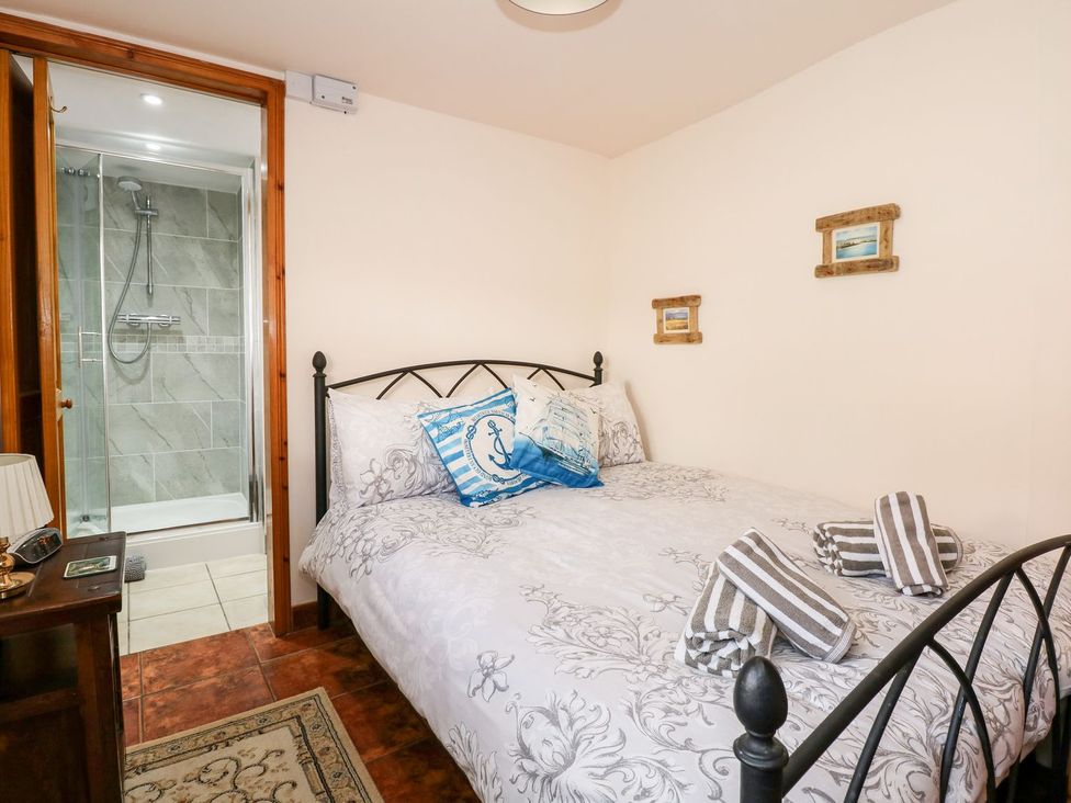 A bedroom with a bed and an attached bathroom at Beck Cottage in Sheringham
