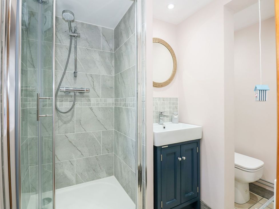 A bathroom with shower, sink, and toilet at Beck Cottage in Sheringham
