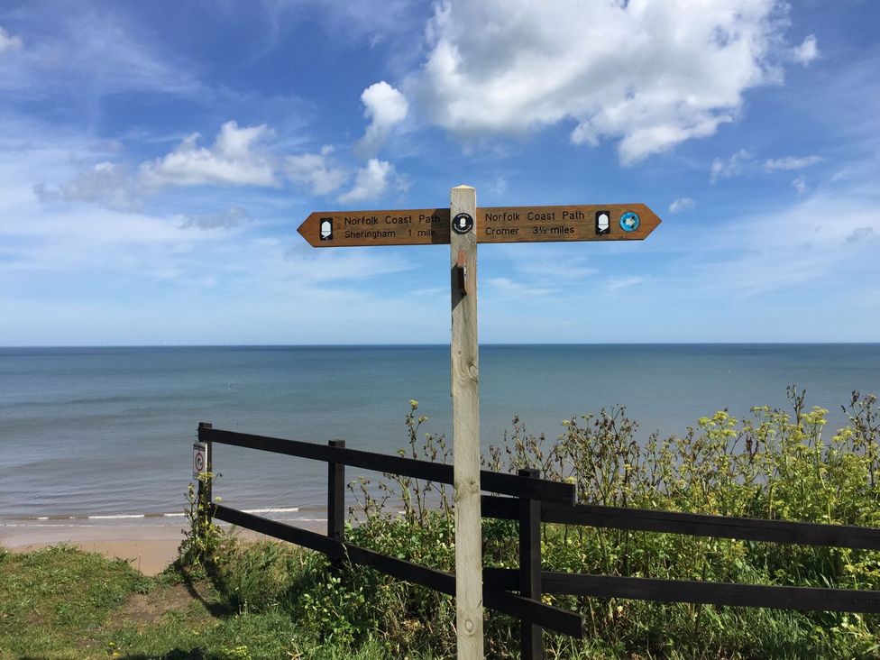 A signpost indicating walking paths at Beck Cottage in Sheringham