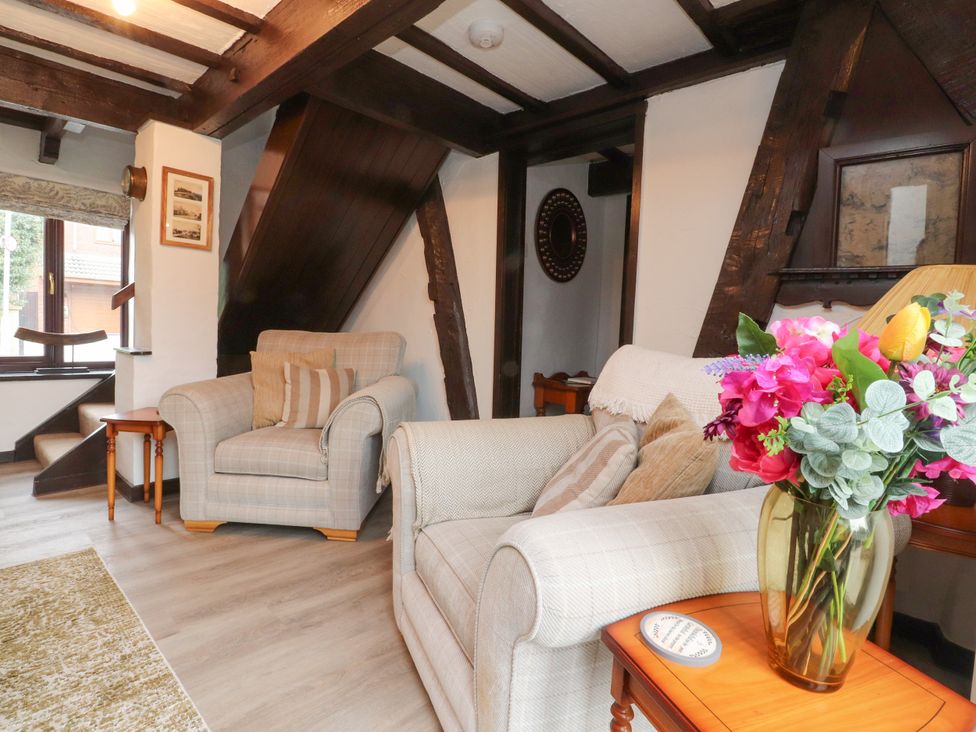 A living room with furniture and flowers at The Thatched Cottage in Preston