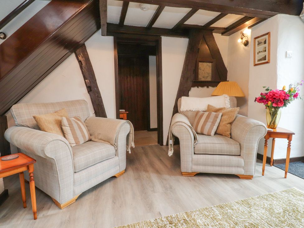 A living room with armchairs and a table at The Thatched Cottage in Preston