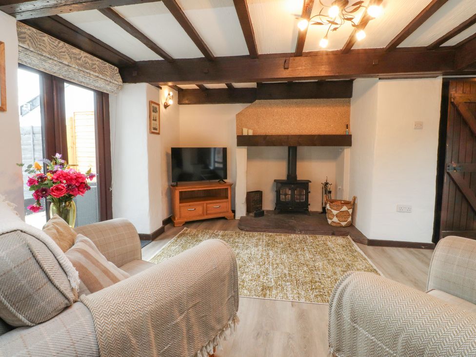 A living room with a television and sofa at The Thatched Cottage in Preston