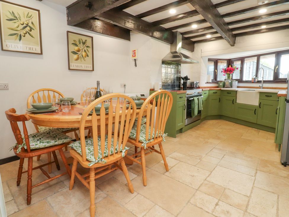 A kitchen with a table and chairs at The Thatched Cottage in Preston