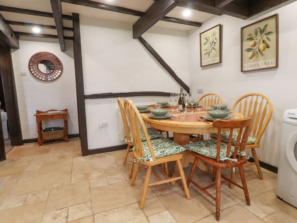A dining room with a table set for meals at The Thatched Cottage in Preston