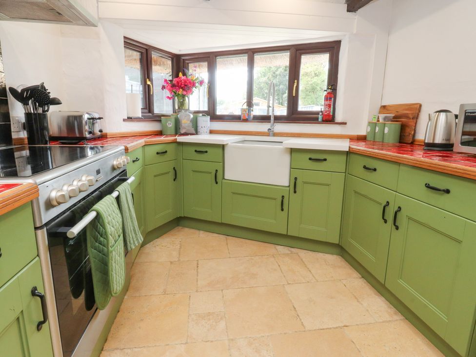 A kitchen with a sink and stove at The Thatched Cottage in Preston