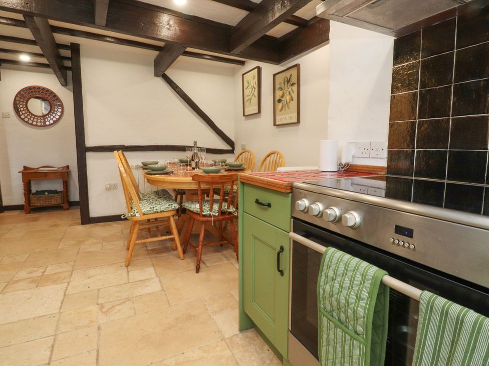A kitchen with a dining table and chairs at The Thatched Cottage in Preston