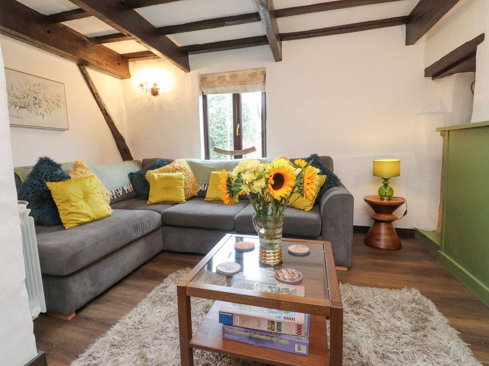 A living room with a sofa and coffee table at The Thatched Cottage in Preston