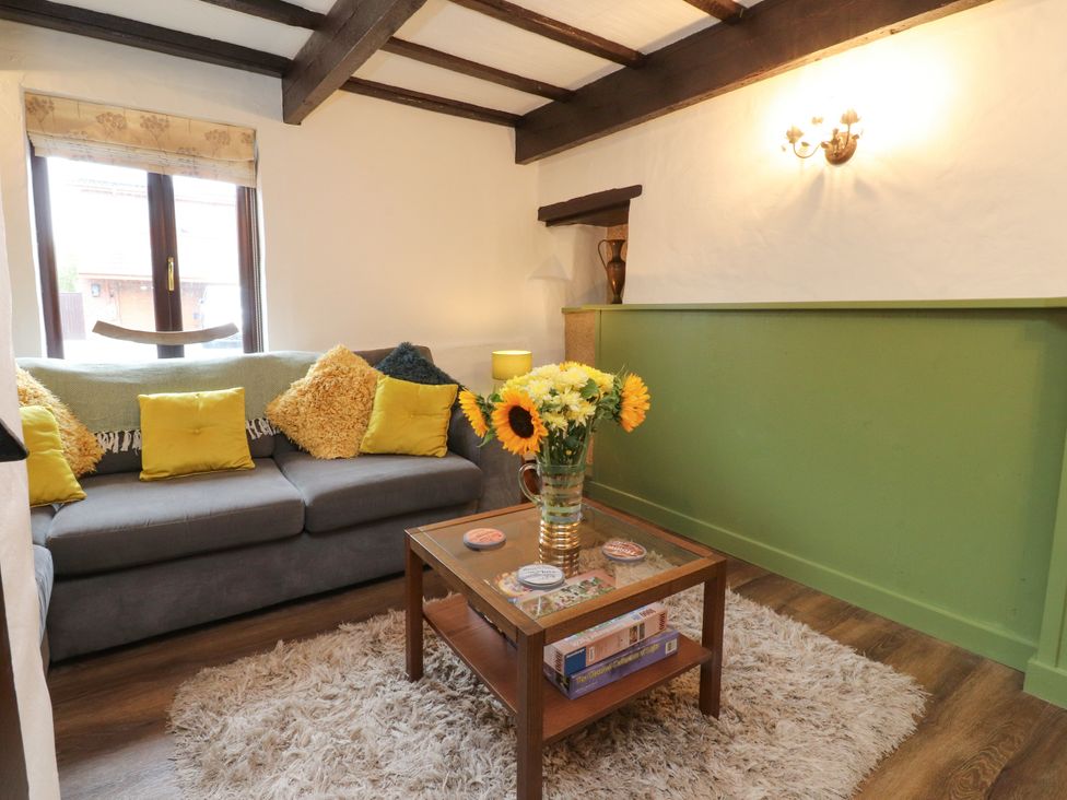 A living room with a sofa and coffee table at The Thatched Cottage in Preston