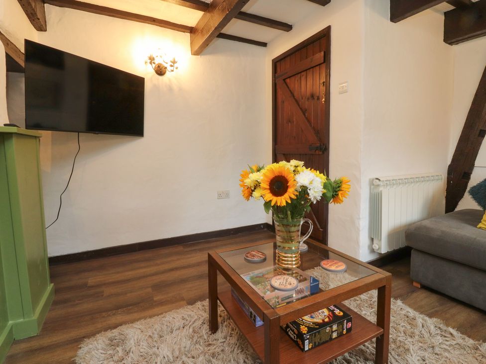 A living room with a television and coffee table at The Thatched Cottage in Preston