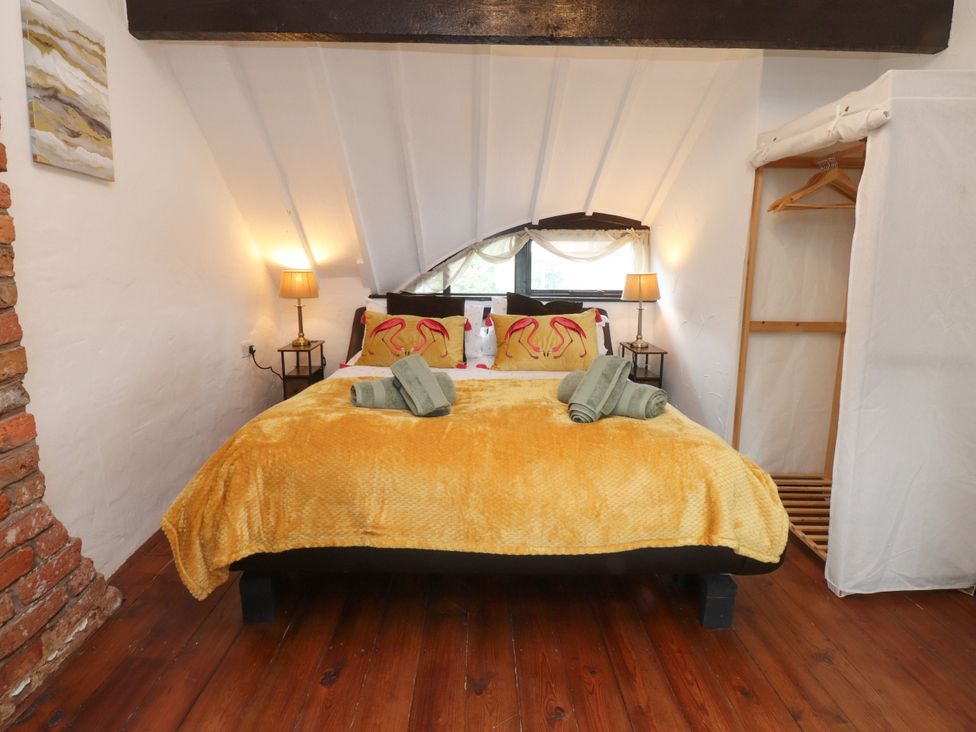 A bedroom with a bed and bedside tables at The Thatched Cottage in Preston
