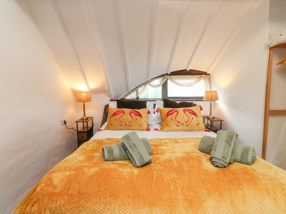 A bedroom with a bed and pillows at The Thatched Cottage in Preston