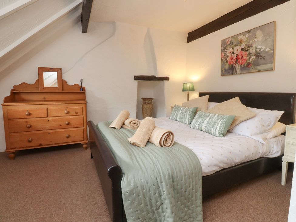A bedroom with a bed and a dresser at The Thatched Cottage in Preston