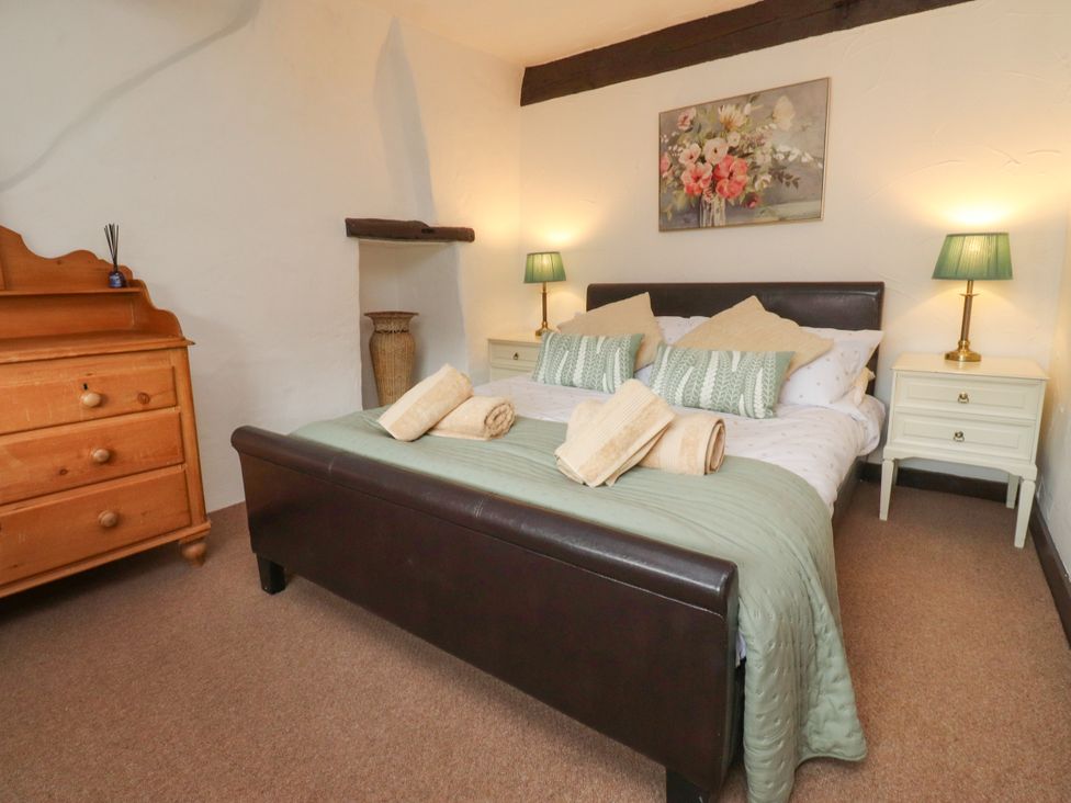 A bedroom with a bed and chest of drawers at The Thatched Cottage in Preston