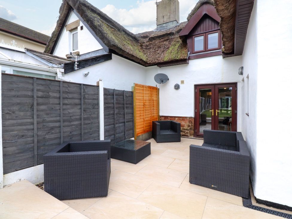 An outdoor area with seating and a fence at The Thatched Cottage in Preston