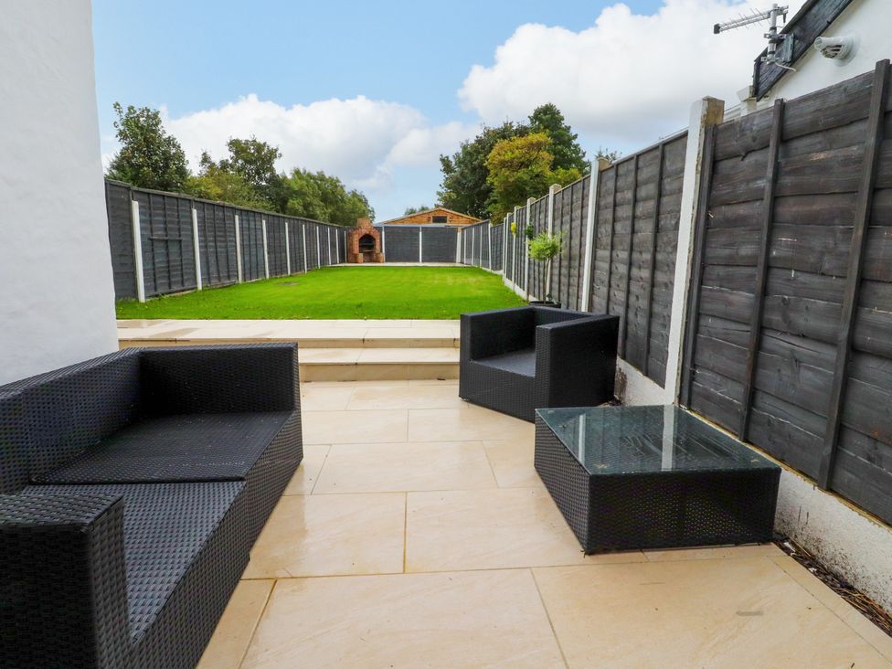 A garden with outdoor furniture and a lawn at The Thatched Cottage in Preston