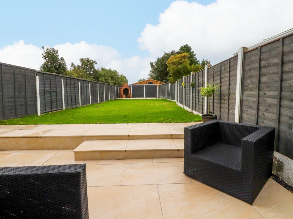 A garden with grass and fences at The Thatched Cottage Preston