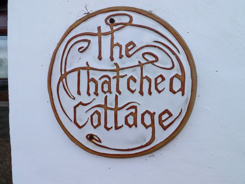 A sign that reads 'The Thatched Cottage' at The Thatched Cottage in Preston
