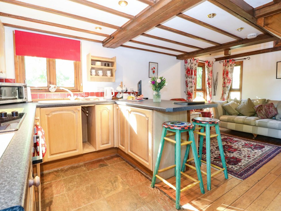 A kitchen with cabinets and stools at Corner Barn North Burlingham near Blofield