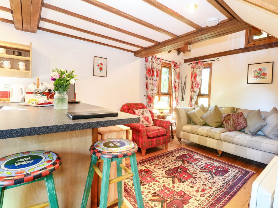 A living room with a sofa and armchair at Corner Barn North Burlingham near Blofield