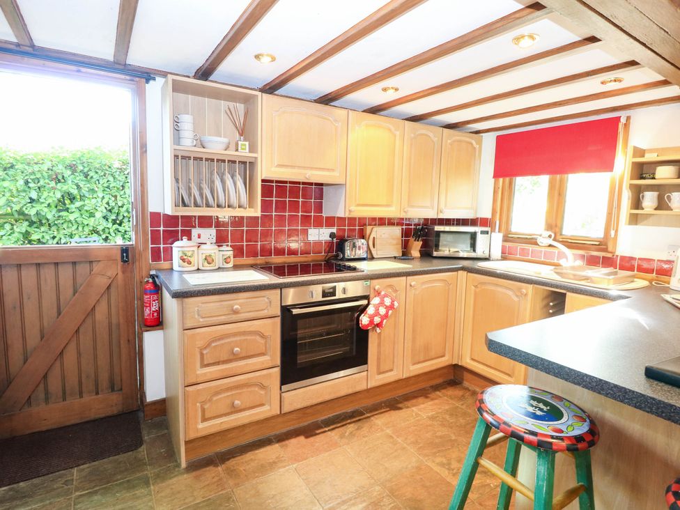 A kitchen with wooden cabinets and appliances at Corner Barn near North Burlingham