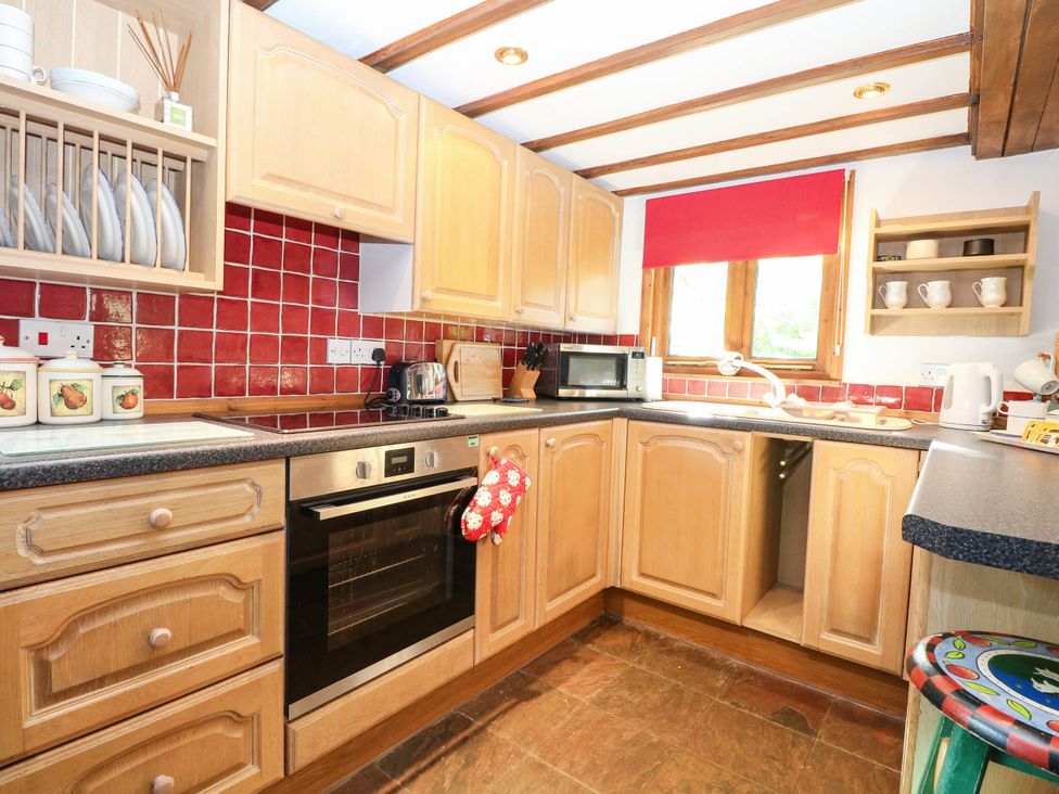 A kitchen with cabinets, an oven, sink, and appliances at Corner Barn North Burlingham near Blofield