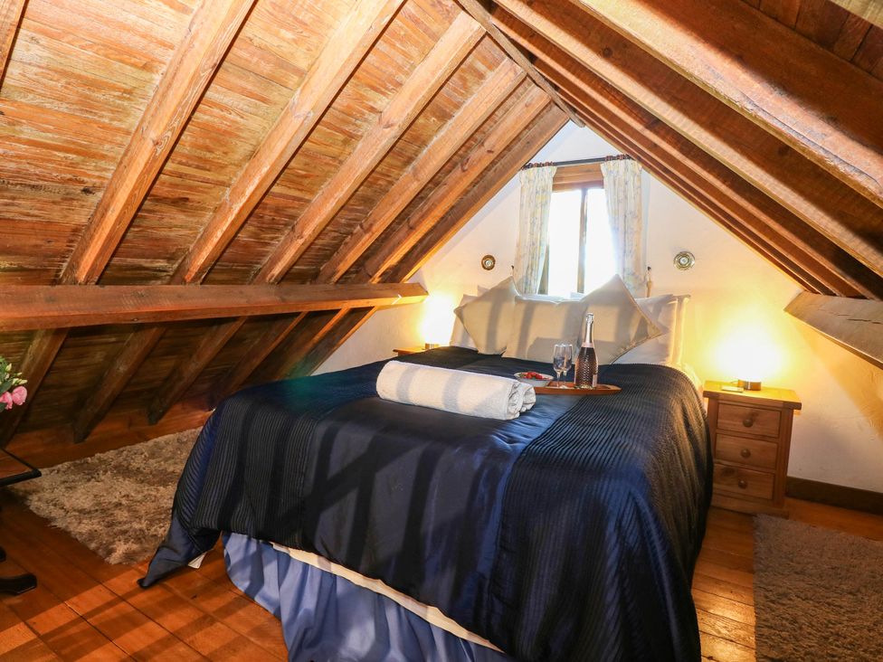 A bedroom with a bed and a window at Corner Barn North Burlingham near Blofield