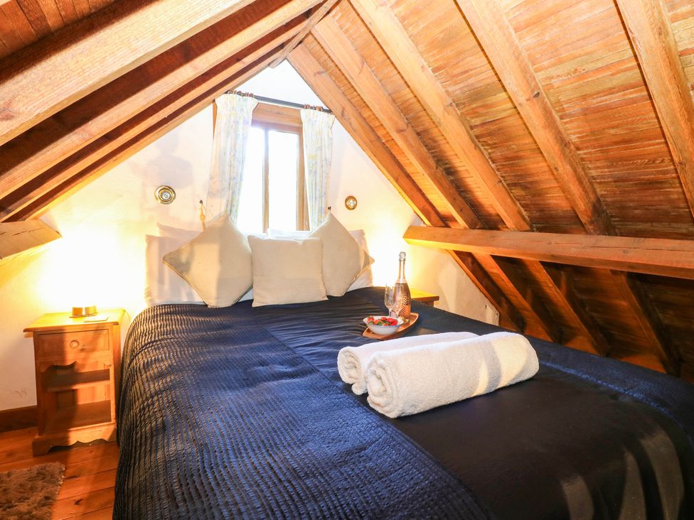 A bedroom with a bed and window at Corner Barn North Burlingham near Blofield