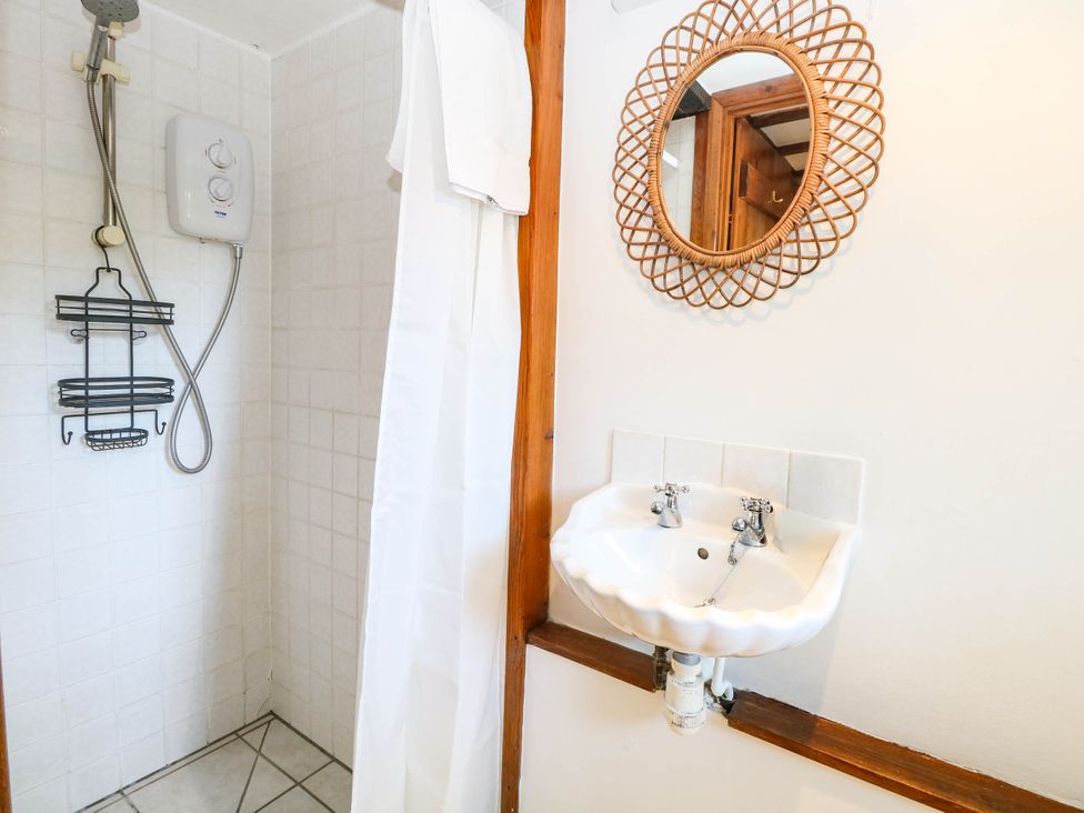 A bathroom with a shower and sink at Corner Barn North Burlingham near Blofield