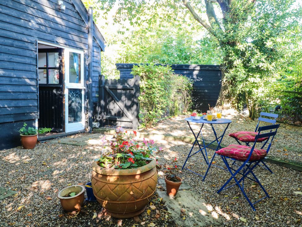 A garden with chairs and a table at Corner Barn in North Burlingham near Blofield