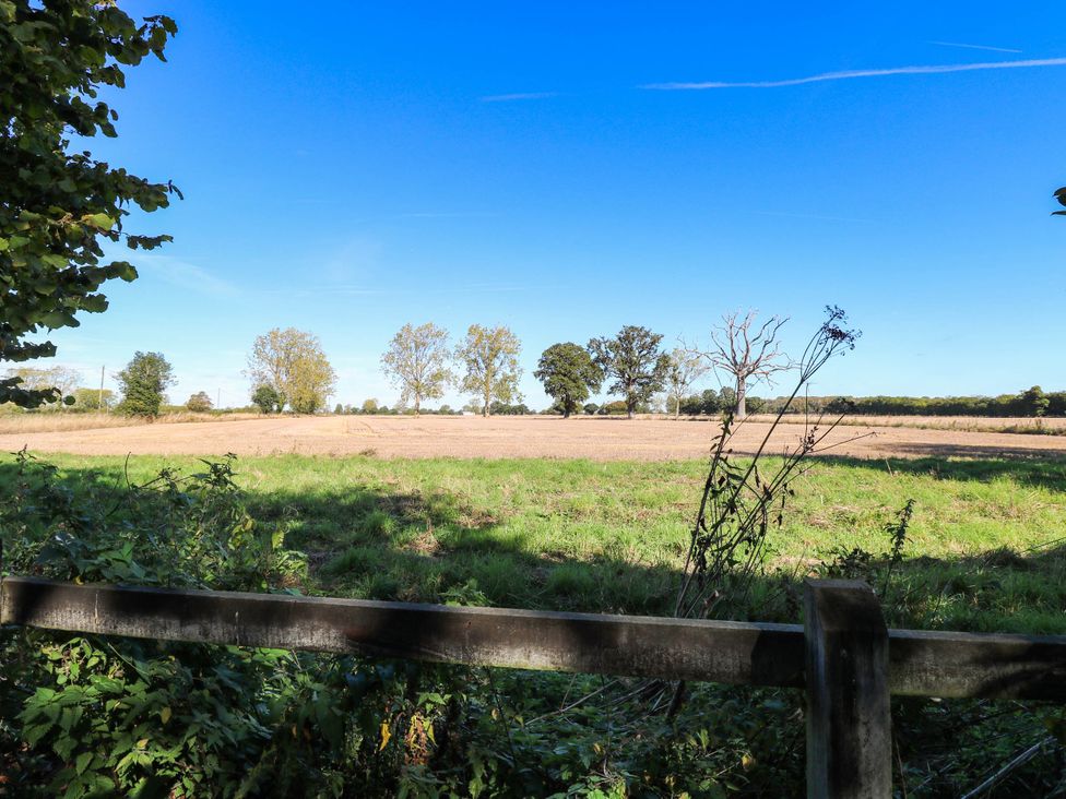 A field with trees and a fence at Corner Barn North Burlingham near Blofield
