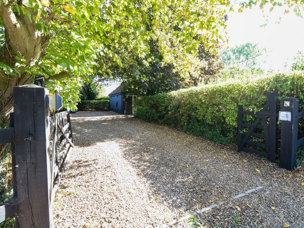 An outdoor area with a gravel driveway and gate at Corner Barn North Burlingham near Blofield