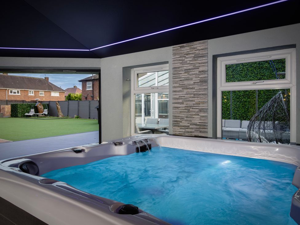 A hot tub with windows and a view of the outdoor patio at Wind Farm