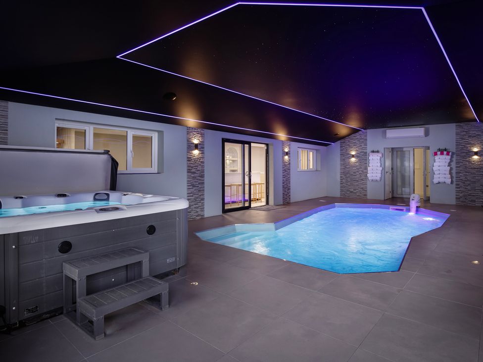 An indoor pool area featuring a hot tub and swimming pool at Wind Farm