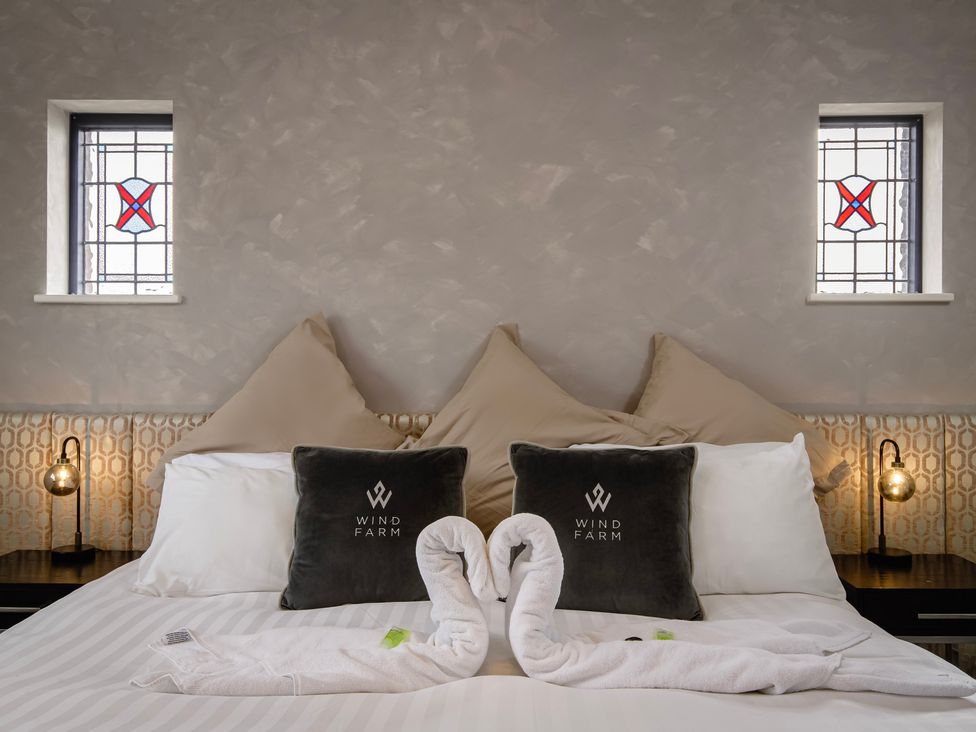 A bedroom with decorative pillows and towel swans at Wind Farm