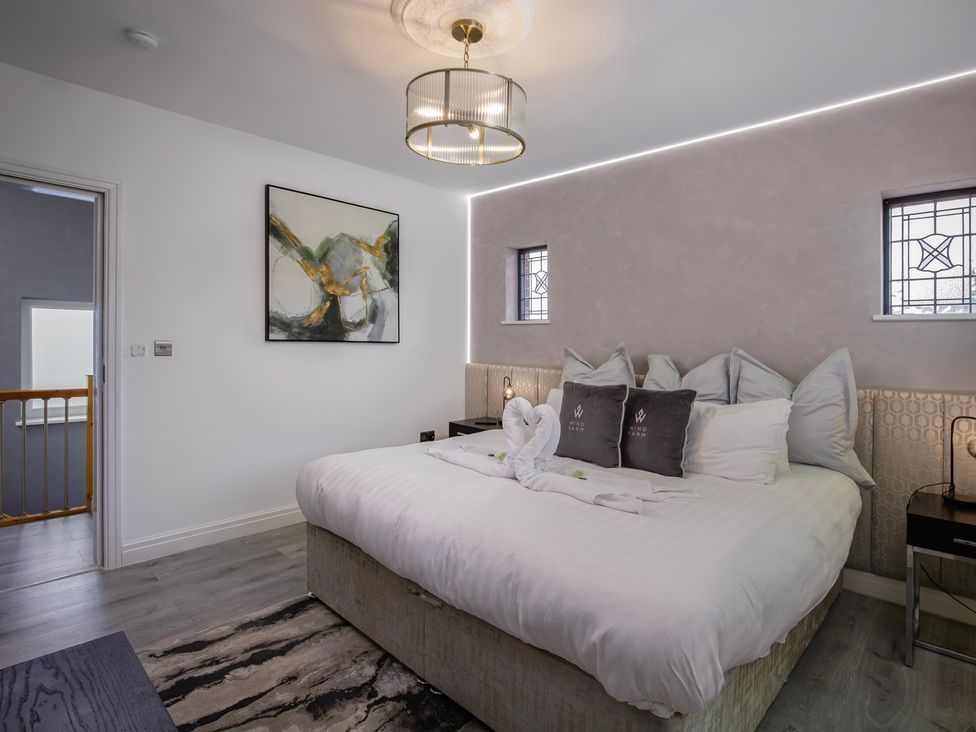 A bedroom with a bed and painting at Wind Farm