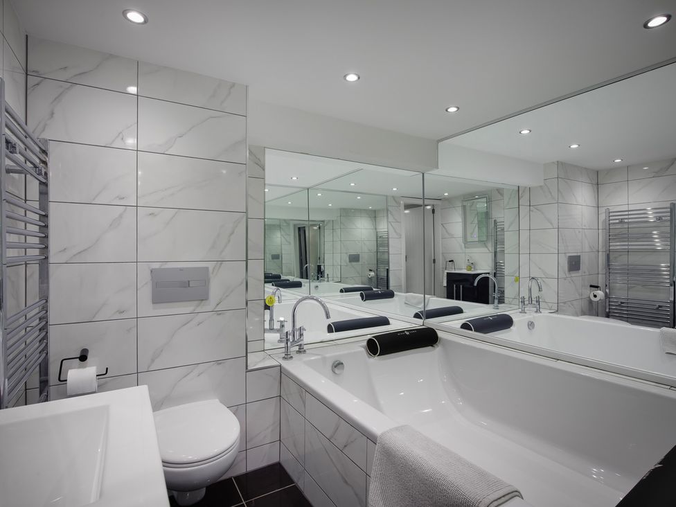 A bathroom with a bathtub, sink, and toilet at Wind Farm in 