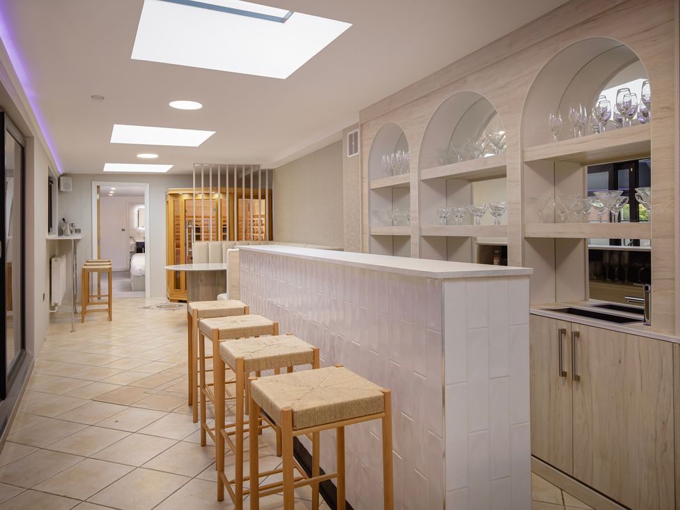 A kitchen with a bar and stools at Wind Farm